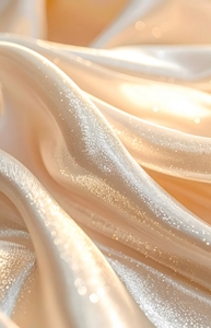 Tela satinada en tonos crema con pliegues suaves y brillo elegante