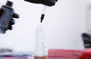Goldwell Product being prepared by adding drops with a pair of tweezers inside of a bottle.