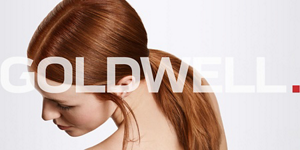 žena sa crvenom dugom kosom sa konjskim repom preko sive pozadine i Goldwell logom ispred