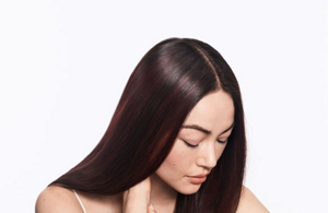 Woman with brown straight hair and light/grey background