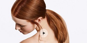 woman with red long hair with low pony tail over gray background with play sign