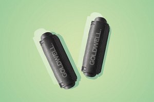 Two black Goldwell curlers on a green background