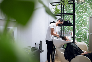 Male stylist washing a woman's hair in a  comfortable environment
