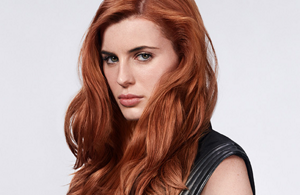 Woman with white short hair in front of bright background 