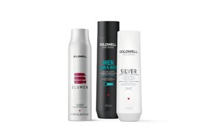 Three bottles of Goldwell, one grey, one black and one white on a white background.