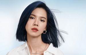 Woman with dark wavy hair in front of bright background and the text Newance Fashion in front