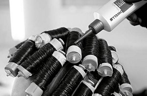 a woman with long hair using goldwell hair spray in black and white