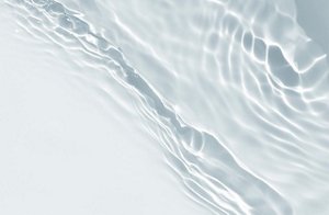 Water flowing over a smooth, light backdrop