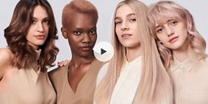 a video thumbnail of four diverse woman with different hair colors and lenghts, which stand side by side and close to each other looking into the camera while standing in front of a clean grey background