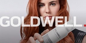 een roodharige europese vrouw met een zwarte jurk die recht in de camera kijkt en een goldwell styling hairspray vasthoudt voor een witte achtergrond 