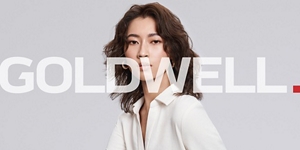 white woman with long blonde hair, which stands in front of a clean grey background looking into the camera