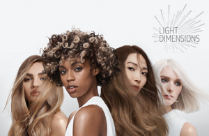 Woman with red hair glancing at the camera on light grey background with the Topchic 50 years logo in the right bottom corner.