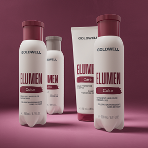 Goldwell Elumen Color image showing three white Elumen Color bottles with burgundy caps arranged on a burgundy pink studio background.