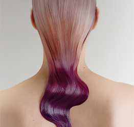  A model faces away from the camera, showing off her vibrant hair color, ranging from soft pink at the roots to deep purple at the tips, thanks to the opportunities on offer with Goldwell's product range.