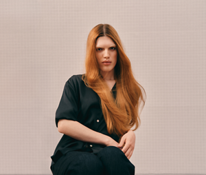 Ein Model präsentiert mit ihrem strahlenden, fließenden roten Haaren die Leuchtkraft der Haarfarben von Goldwell.