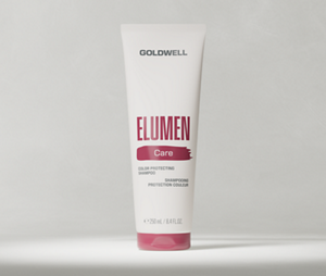 Goldwell Elumen Care packshot showing a white Elumen Shampoo tube standing on a light grey studio background.