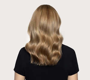 Εικόνα μετά τη χρήση του Goldwell Dualsenses Blondes & Highlights, στην οποία απεικονίζεται ένα άτομο από πίσω με πιο απαλές, λαμπερές ξανθές μπούκλες και μαύρο τοπ, με φόντο ένα ουδέτερο φόντο στούντιο.