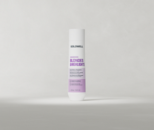 Un flacon de 300 ml de shampoing Goldwell Dualsenses Blondes & Highlights, posé à la verticale sur un fond de studio gris clair et doux.