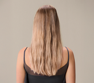 Before image showing the back of a model's hair prior to using Goldwell's Dualsenses Bond Pro range, displaying signs of damage and breakage