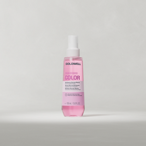 Goldwell Dualsenses Color Spray Serum 150 ml pink bottle standing upright on a soft light grey studio background.