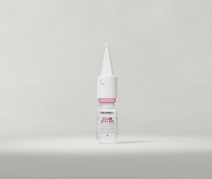 Goldwell Dualsenses Color Extra Rich Intensive Conditioning Serum ampoule standing upright on a soft light grey studio background.