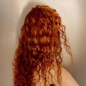 A model's long orange defined waves are nourished and hydrated thanks to Goldwell's range.
