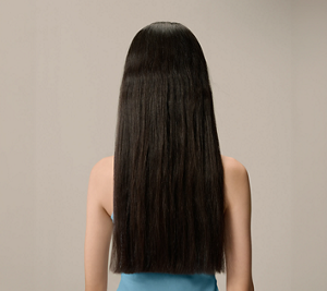 Goldwell Dualsenses Pure Hydration before image showing a person from behind with long dark hair against a neutral studio background.