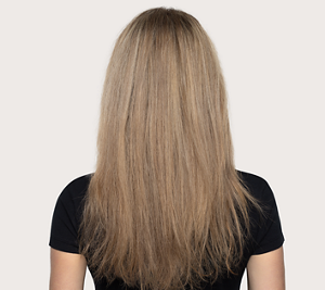 Goldwell Dualsenses Rich Repair before image showing a person from behind with long dry blonde hair against a neutral studio background.