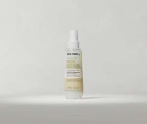 Goldwell Dualsenses Rich Repair Restoring Serum Spray bottle standing upright on a soft light grey studio background.