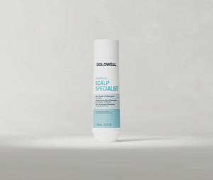 Eine Flasche Goldwell Dualsenses Scalp Specialist Anti-Schuppen-Shampoo, die aufrecht auf einem weichen, hellgrauen Studiohintergrund steht.