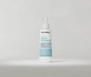 Eine Pumpflasche mit dem Produkt „Goldwell Dualsenses Scalp Specialist Rebalance Hydrate Fluid“, die aufrecht auf einem weichen, hellgrauen Studiohintergrund steht.