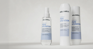 Goldwell Dualsenses Pure Hydration haircare products shown as three white and blue bottles on a soft light grey studio background.