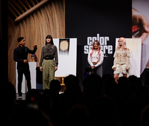On stage at Goldwell's Color Sphere event, a stylist talks to an audience about the looks he's created