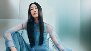 Goldwell Dualsenses campaign image featuring a model with long dark hair in a blue editorial setting