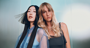 Goldwell Dualsenses hero banner featuring two models with styled hair in blue-toned editorial setting