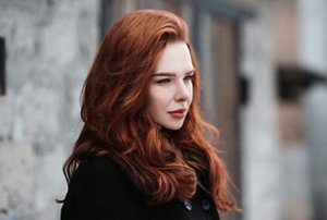 Woman outside in winter with long, thick red hair