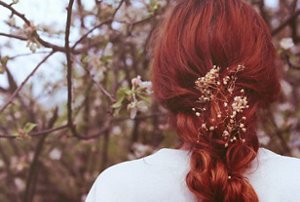 Woman with long red velvet hair with floral decorations