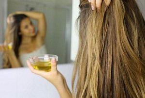 Woman applying nourishing avocado oil into her lengths