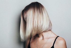 Blonde woman with shiny hair after applying avocado oil