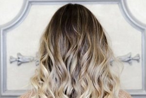 Woman with wavy mid-length ash blonde and brunette balayage