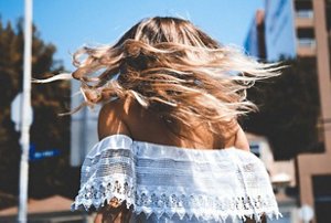 Woman outside turning around to show off her balayaged hair