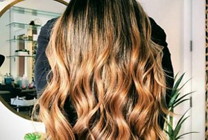 Rich honey and bronze balayage on dyed black hair