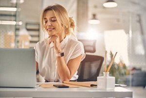 Smiling woman wearing a white shirt working in an office