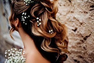 Bride with half up, half down hairstyle styled with flowers