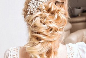 Blonde bridesmaid with a half-up twist hairstyle with loose, flowing curls