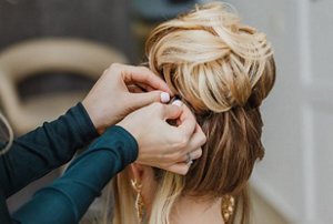 Blonde bridesmaid with a sleek high bun hairstyle
