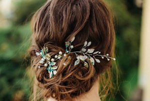 Bridesmaid with a low bun hairstyle with glittery accessories