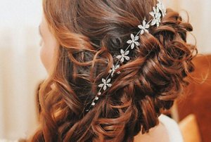 Bridesmaid with auburn hair styled in a side swept updo
