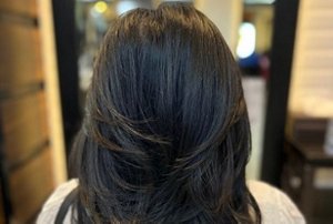 Woman with a butterfly haircut with long, voluminous layers