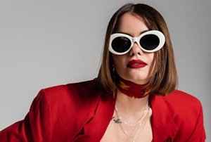 Gen Z woman with 90s-style sunglasses and deep brunette cherry cola hair colour